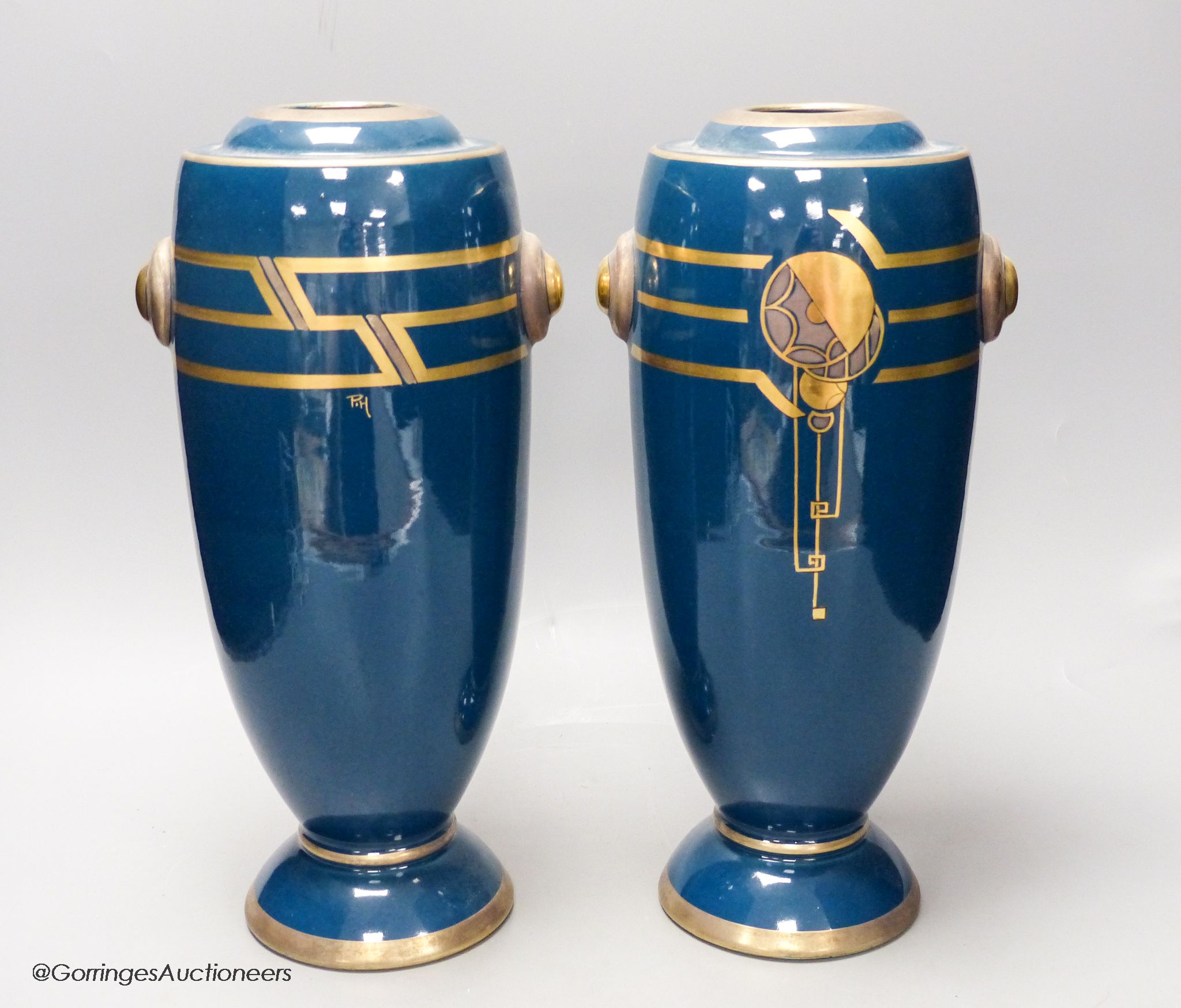 A pair of Art Deco blue glazed pottery vases, initialled PH, height 36cm